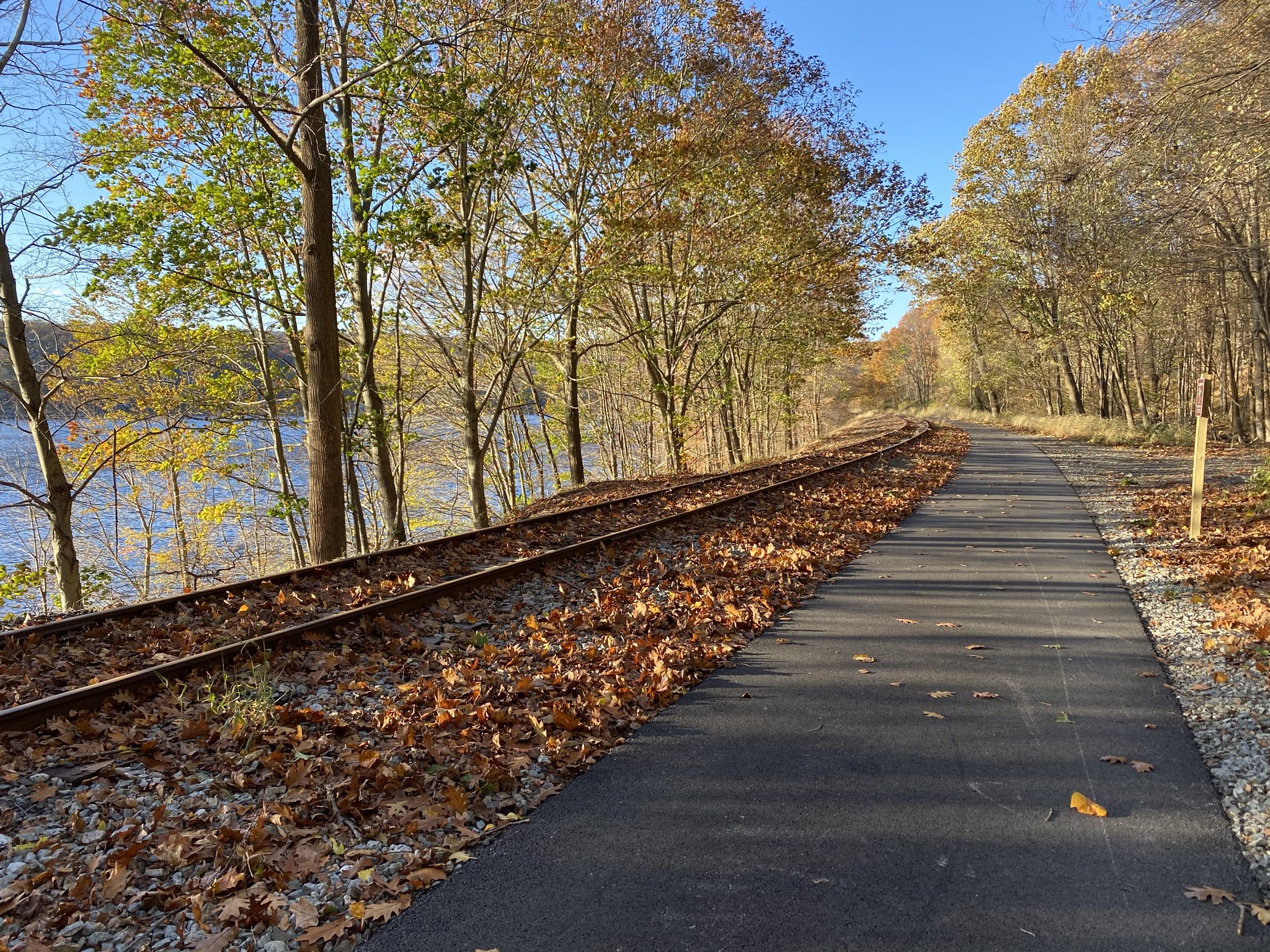 Paved trail next to decommissioned rail line next to body of water