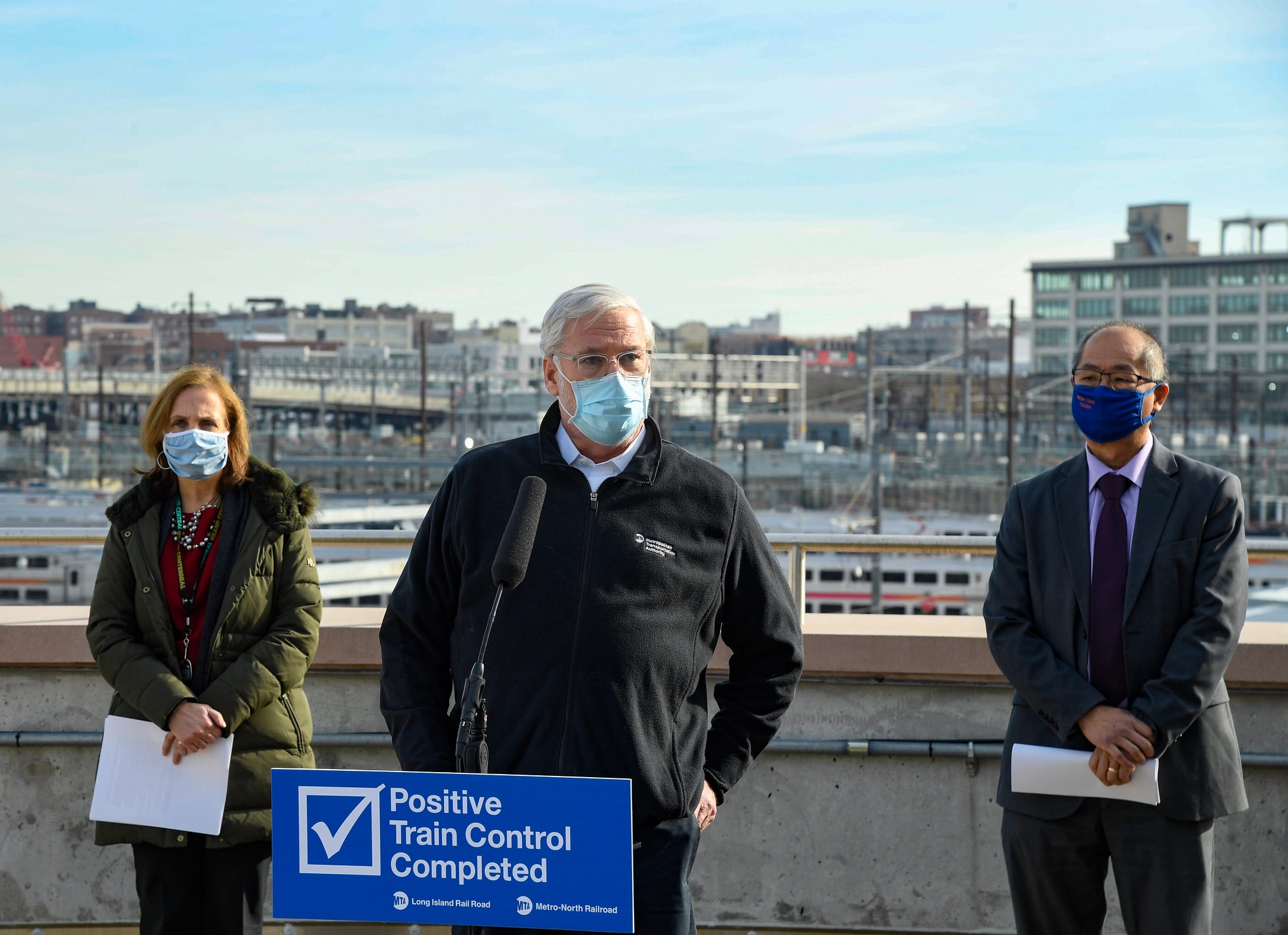 MTA CEO Patrick Foye at a podium on a rooftop overlooking Harold Interlocking