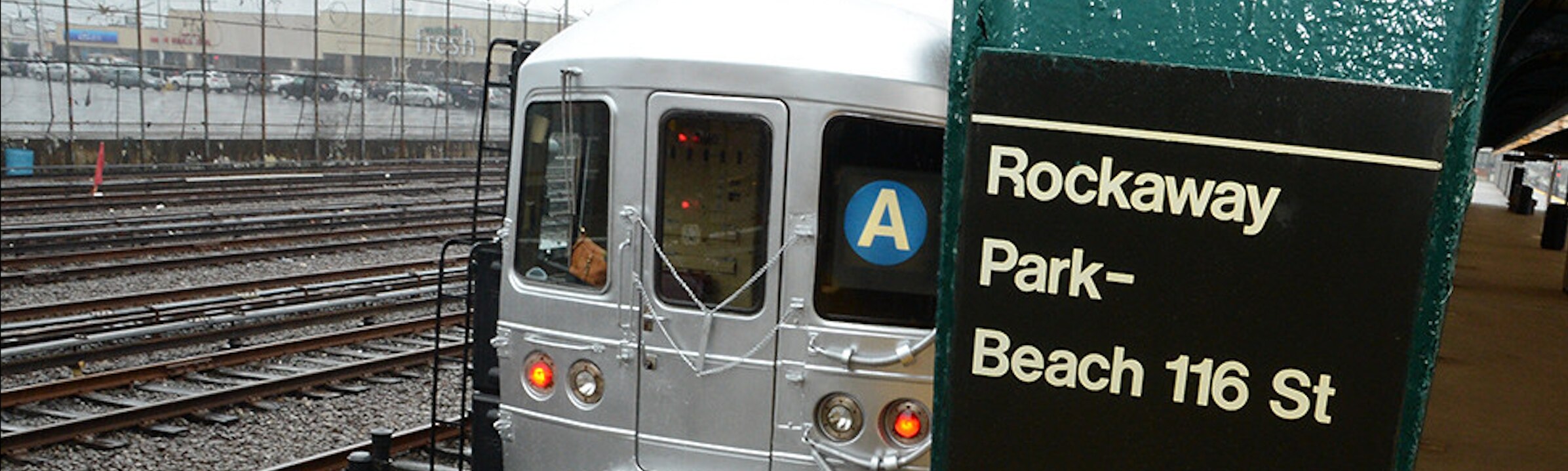 A sign reading "Rockaway Park-Beach 116th Street" and a train. 