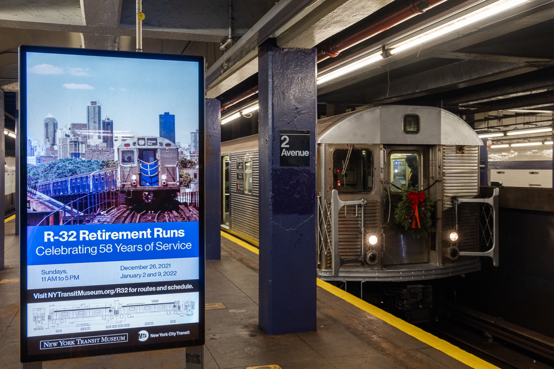 R32 Arriving at Second Avenue Station with digital screen to the left displaying the R32 retirement announcement