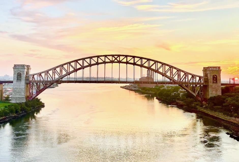 The Hell Gate Bridge, seen from the RFK-Triboro Bridge, with the sky many colors as the sun rises over Queens