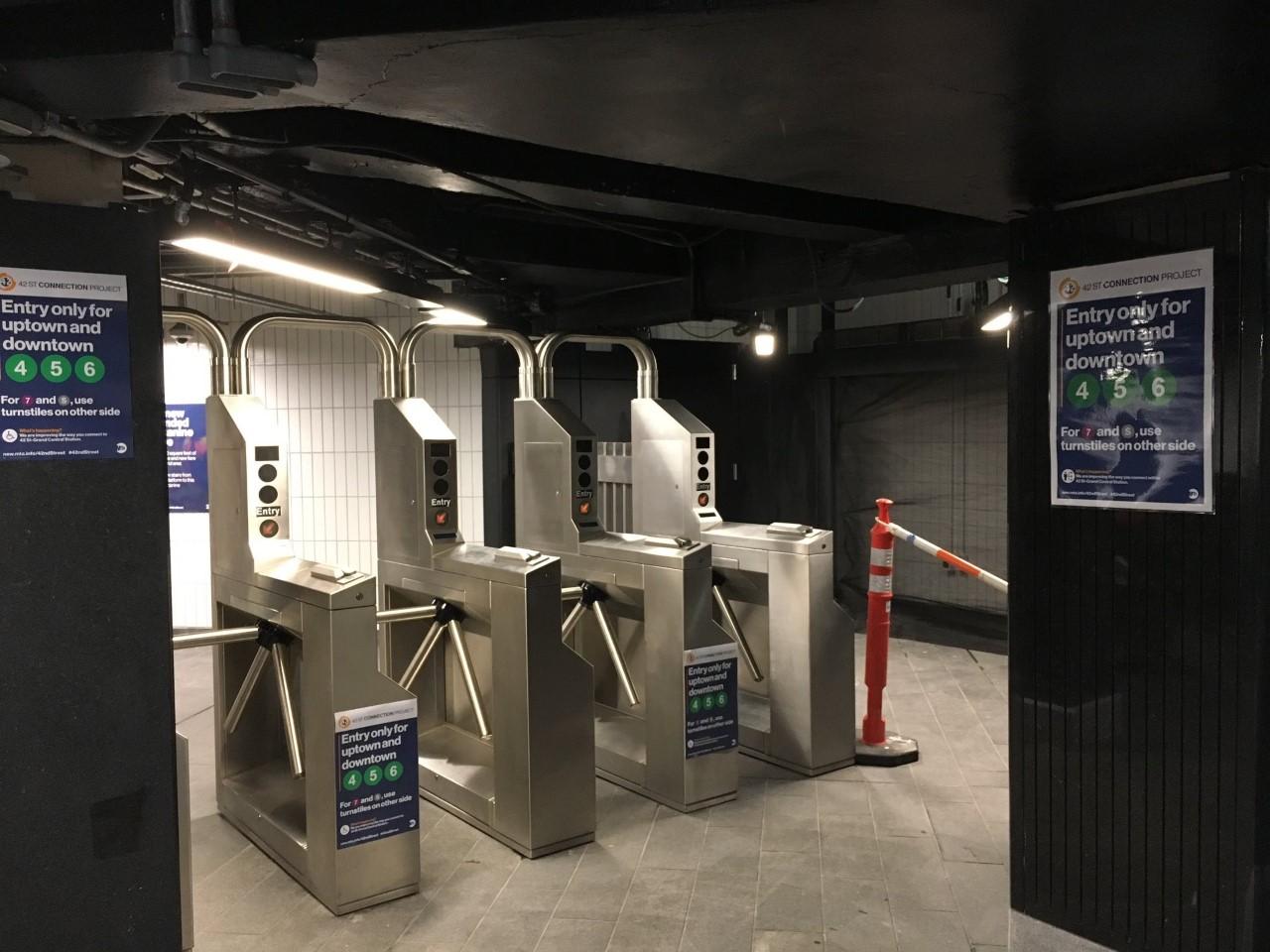 Four new subway turnstiles at Grand Central Station, with signs saying they're for uptown and downtown 4,5, and 6 service only. 
