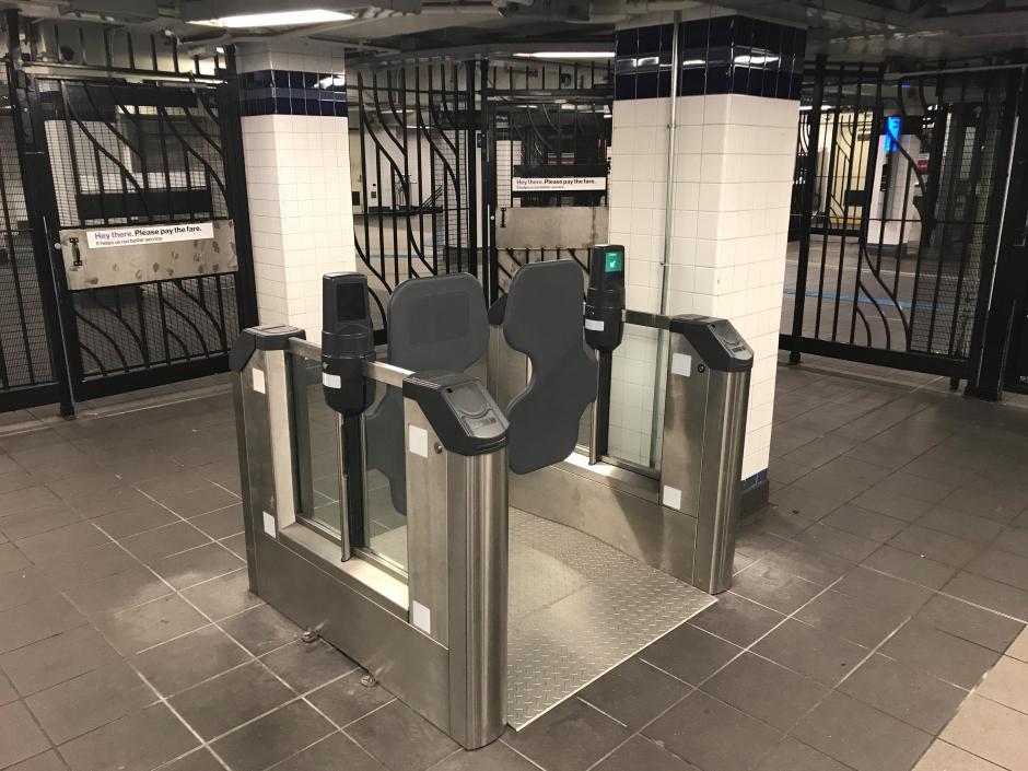demonstration wide fare gate on display at a subway station.