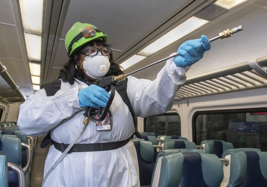 A Coach Cleaner disinfects a Metro-North rail car