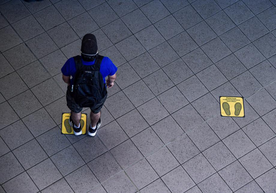 A man standing on a social distance floor marking