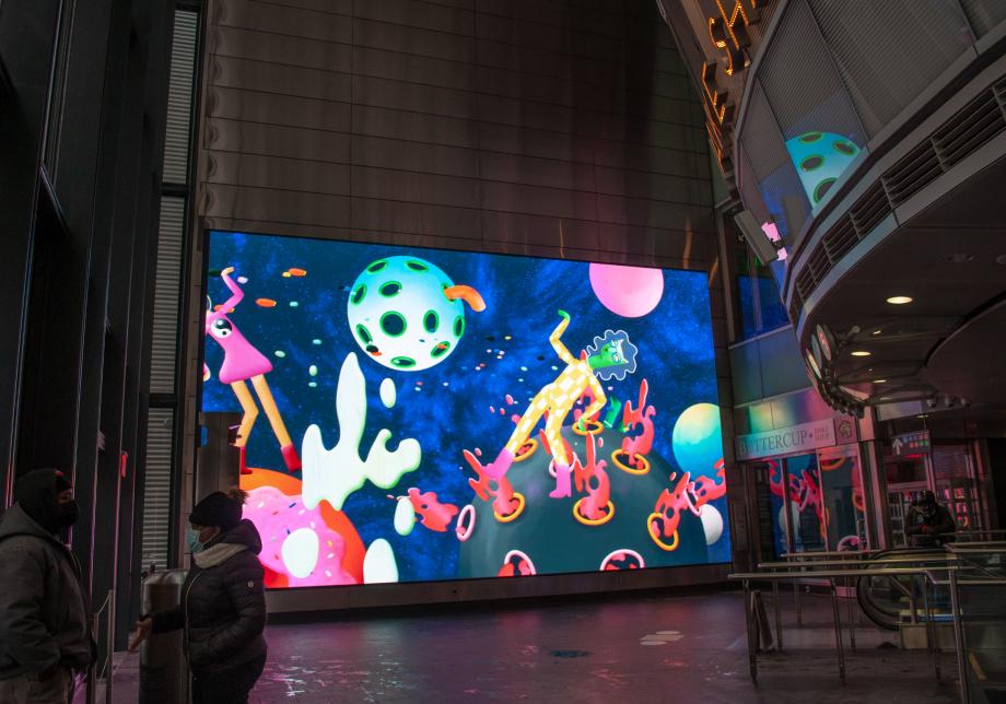 The photo shows digital artwork, Space Trip, created by Jordan Bruner at Fulton Center. Large horizontal screen displays animated figures. 
