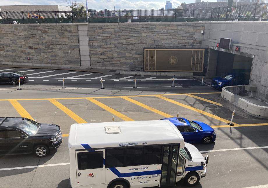 At the entrance to the Queens Midtown Tunnel, the large portal door is visible as an Access-A-Ride van goes into the tunnel.