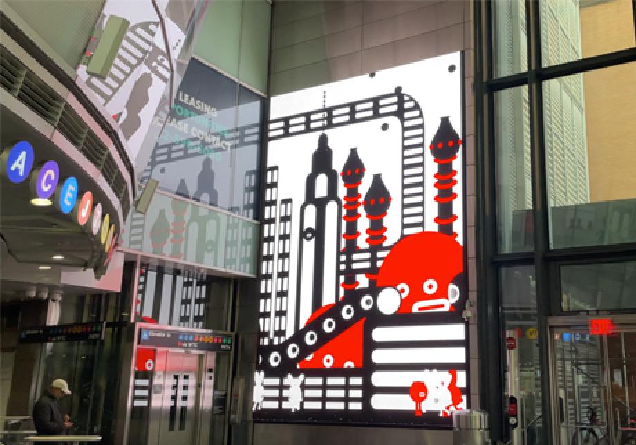 Fulton Center station featuring a large digital screen with a red, white, and black illustration.