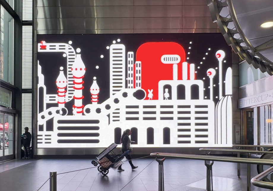 Fulton Center station featuring a large digital screen with a red, white, and black illustration.