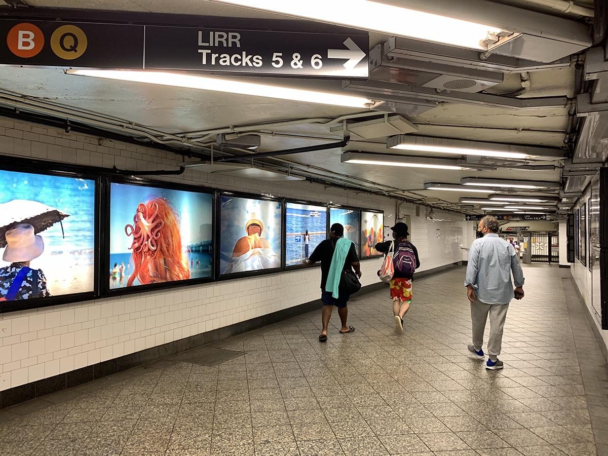 The photo shows photographic artwork, Last Stop: Coney Island, created by Ruben Natal-San Miguel at Atlantic Avenue – Barclay's Center. The large scale photographs are displayed in Lightboxes in the station’s mezzanine, and depict brightly colored scenes of Coney Island.  