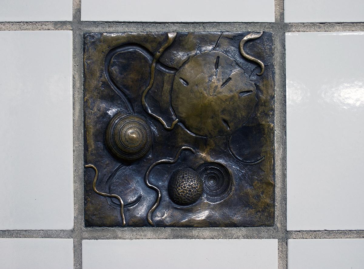 Photo of Steve Wood bronze relief artwork installed in 137 St-City College station wall. 