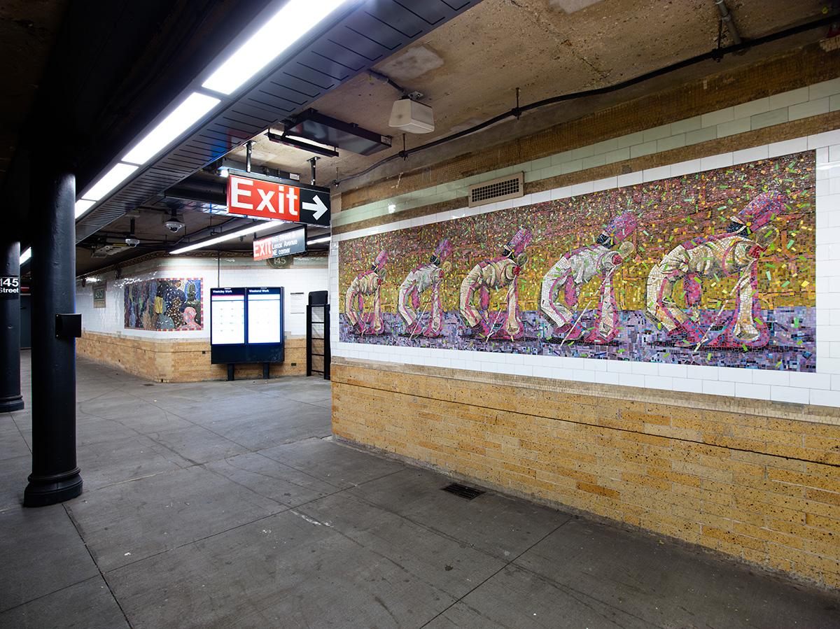 Photo of mosaic artwork panels on station walls on the right and station columns on the left.  