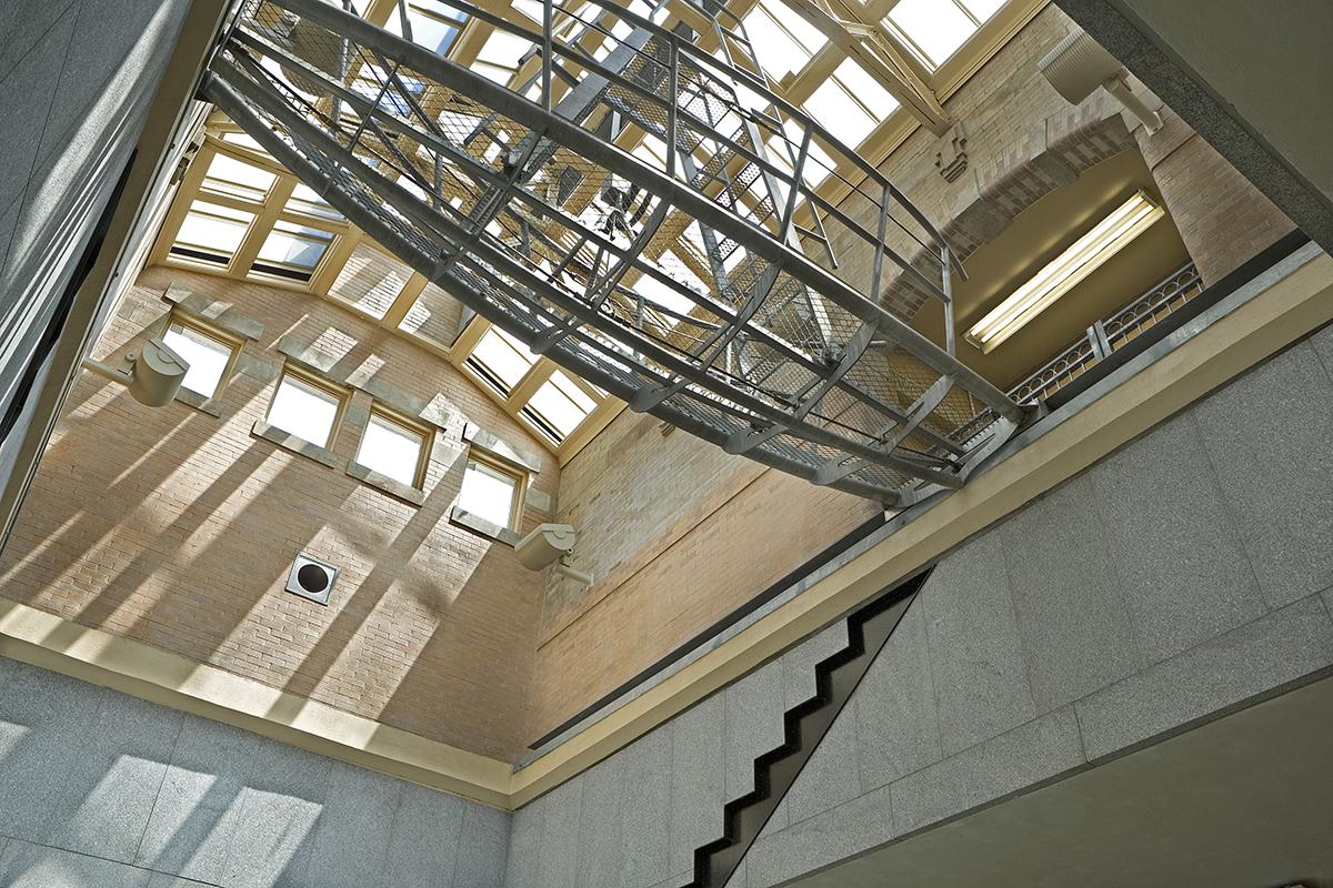 Artwork in stainless steel by George Trakas showing a boat shaped sculpture beneath a ceiling skylight. 