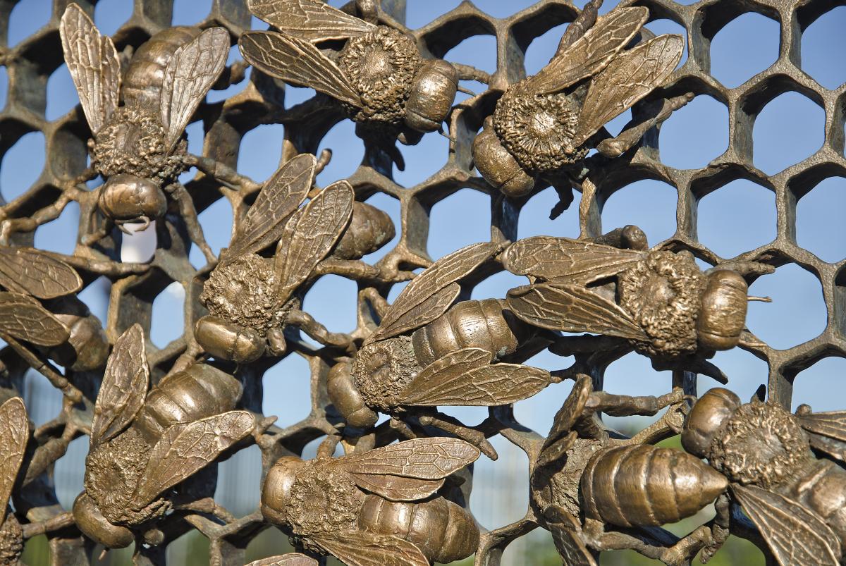 Artwork in Cast bronze by Christopher Russell showing gates with honeycombs and bees. 