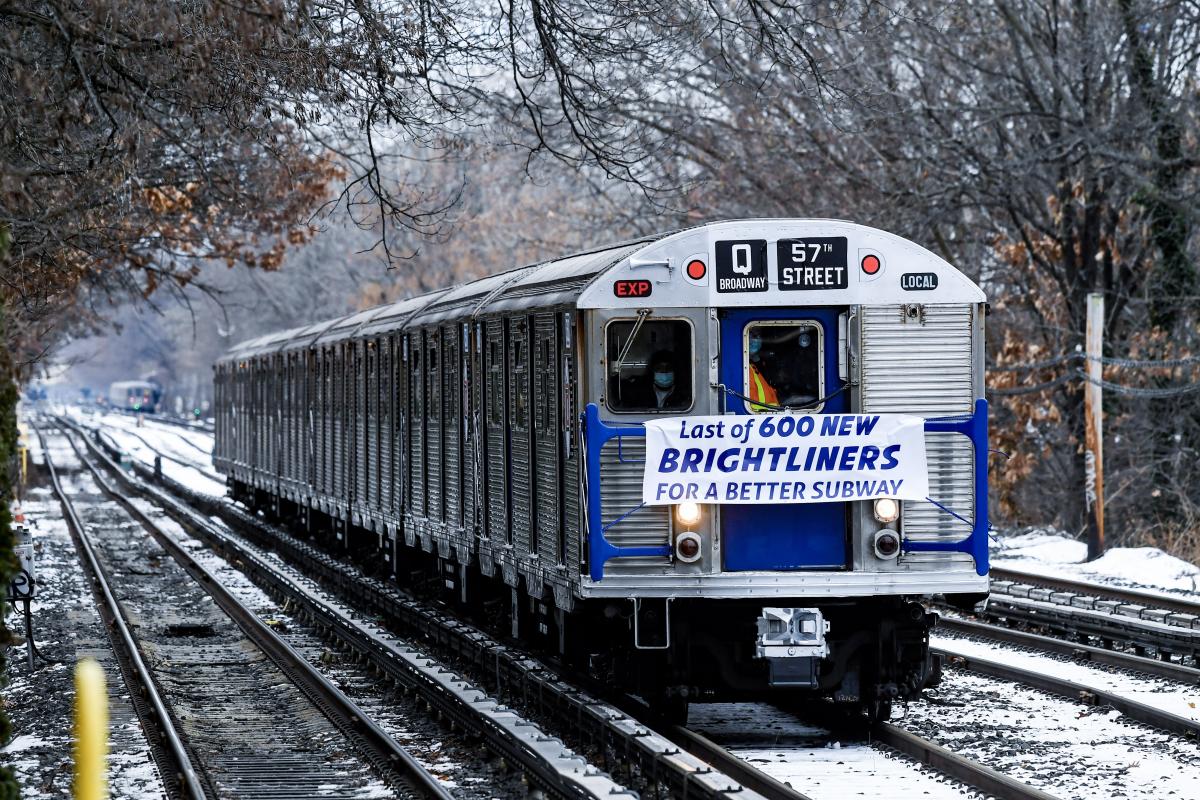 A subway car on a track that is covered in snow. 