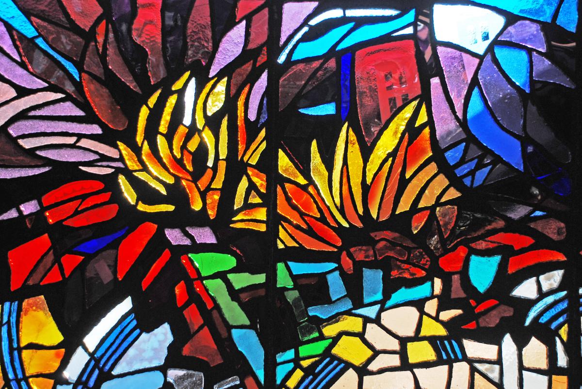 Artwork in faceted glass by Lisa Amowitz showing colorful flowers in platform windscreens and station niches.