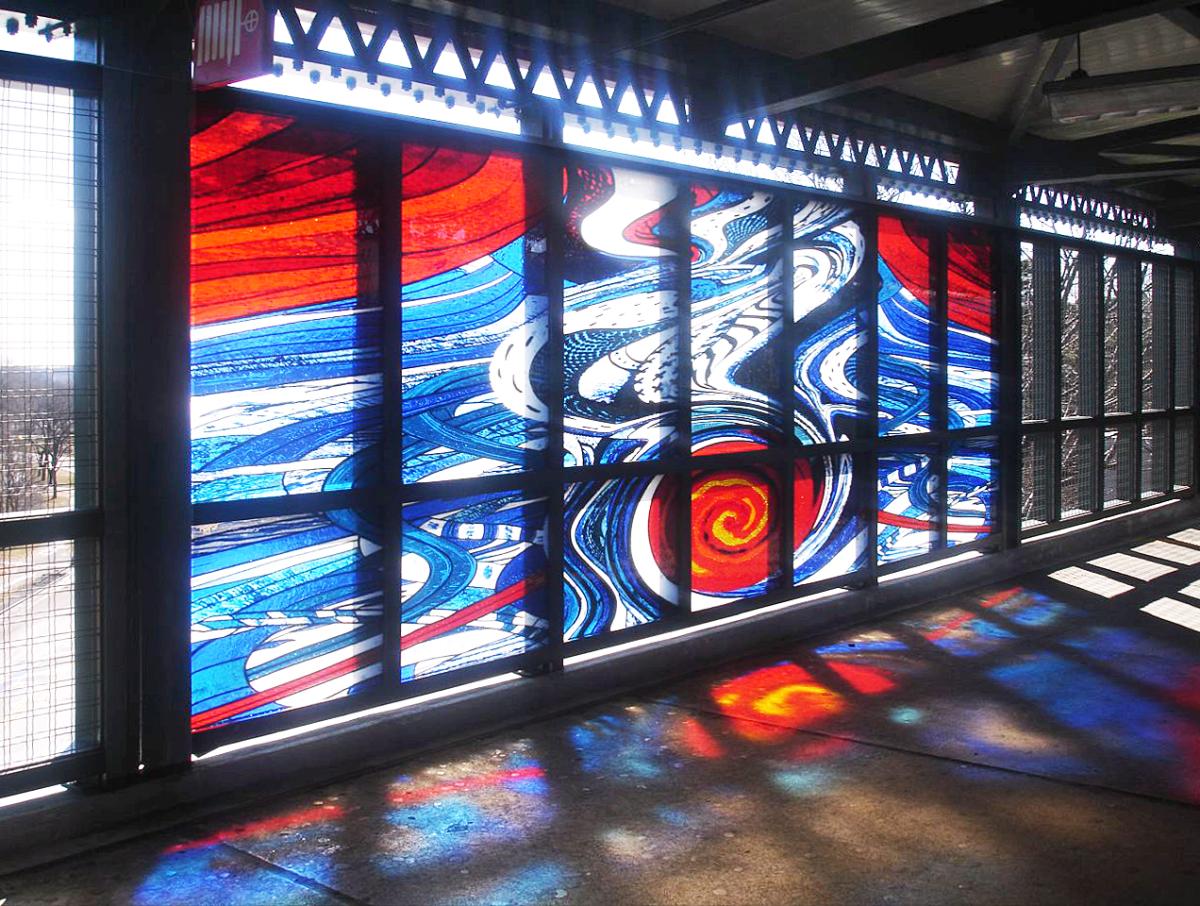 Artwork in fused glass by Corinne Grondahl showing abstract panels of large brushstrokes and movement in reds, blues and whites.