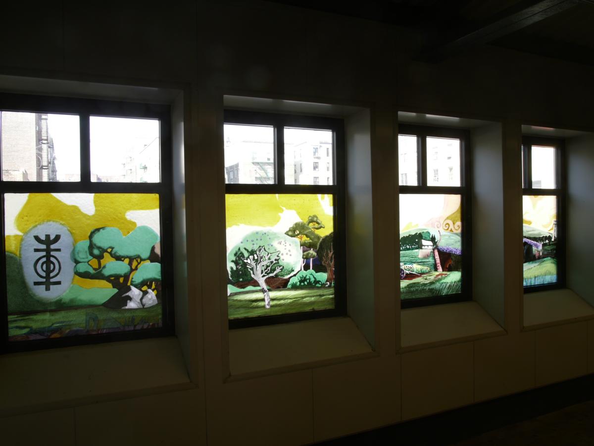 Artwork in laminated glass by José Ortiz showing colorful landscapes and buildings.