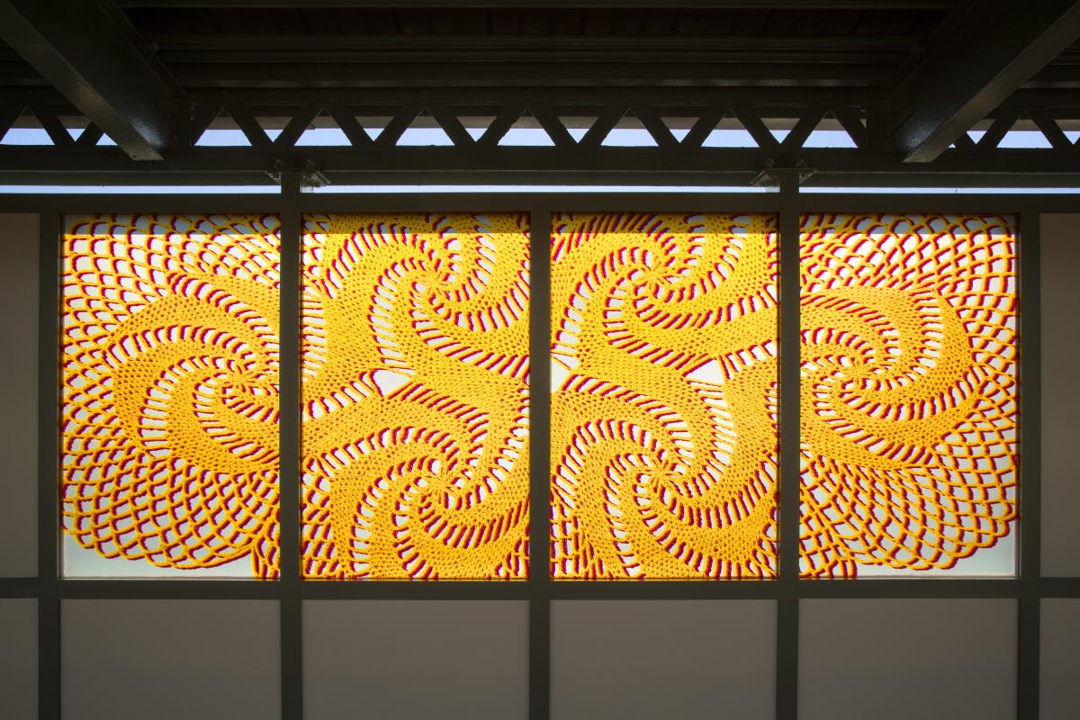 Artwork in laminated glass by Susanna Starr showing colorful shapes that resemble lace. 