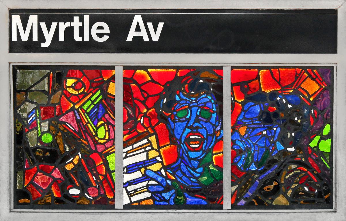 Artwork in glass by Verna Hart showing bright colored scenes of musicians playing instruments.