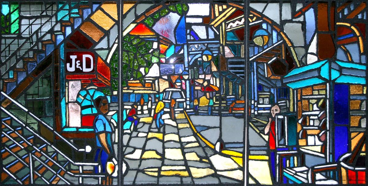 Artwork in faceted glass by Daniel Hauben showing colorful scenes of Bronx streets.