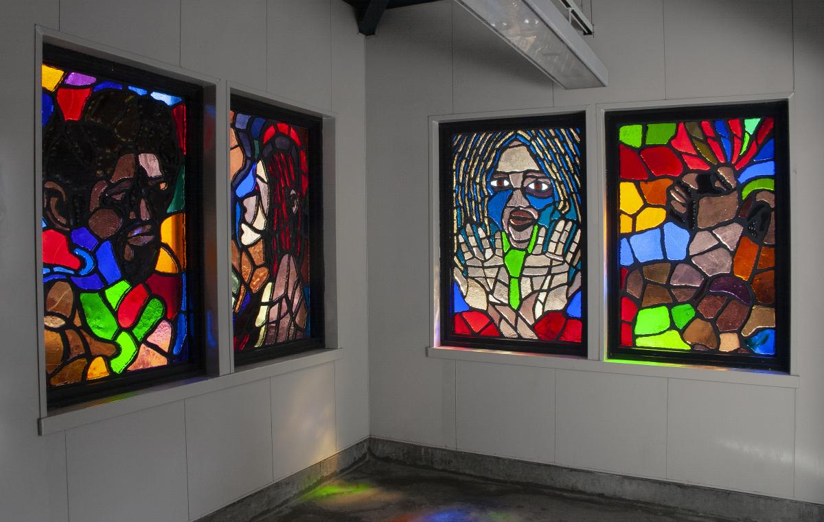 Artwork in faceted glass by Amir Bey showing faces in blocks of color. 