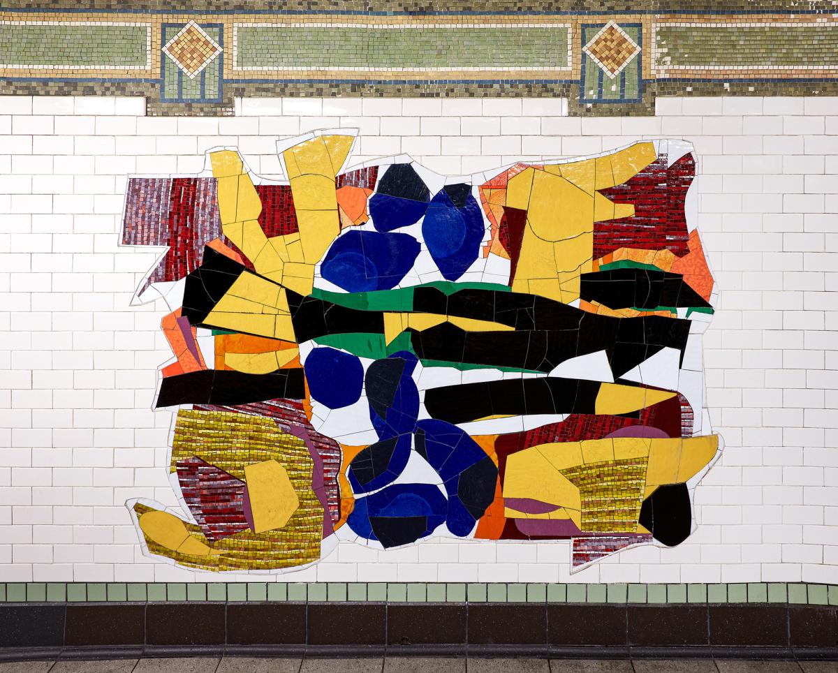 Artwork in glass mosaic by Robert Blackburn showing colorful abstract patterns in large shapes on the platform walls. 