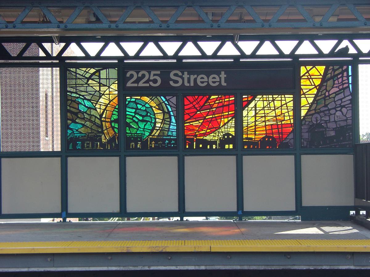 Artwork in faceted glass by Nicky Enright showing cityscapes with vast colorful skies. 