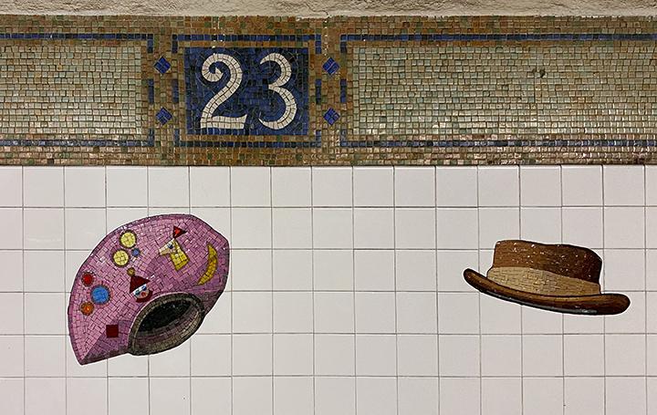 Artwork in glass mosaic by Keith Goddard showing hats on the platform walls. 