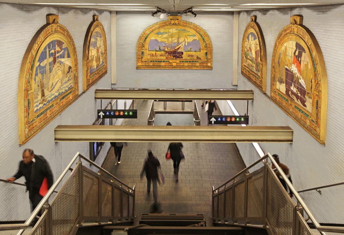 Artwork by Frederick Dana Marsh showing glazed terracotta maritime themed murals above the stairs and a painted cast iron gate at the platform entrance. 