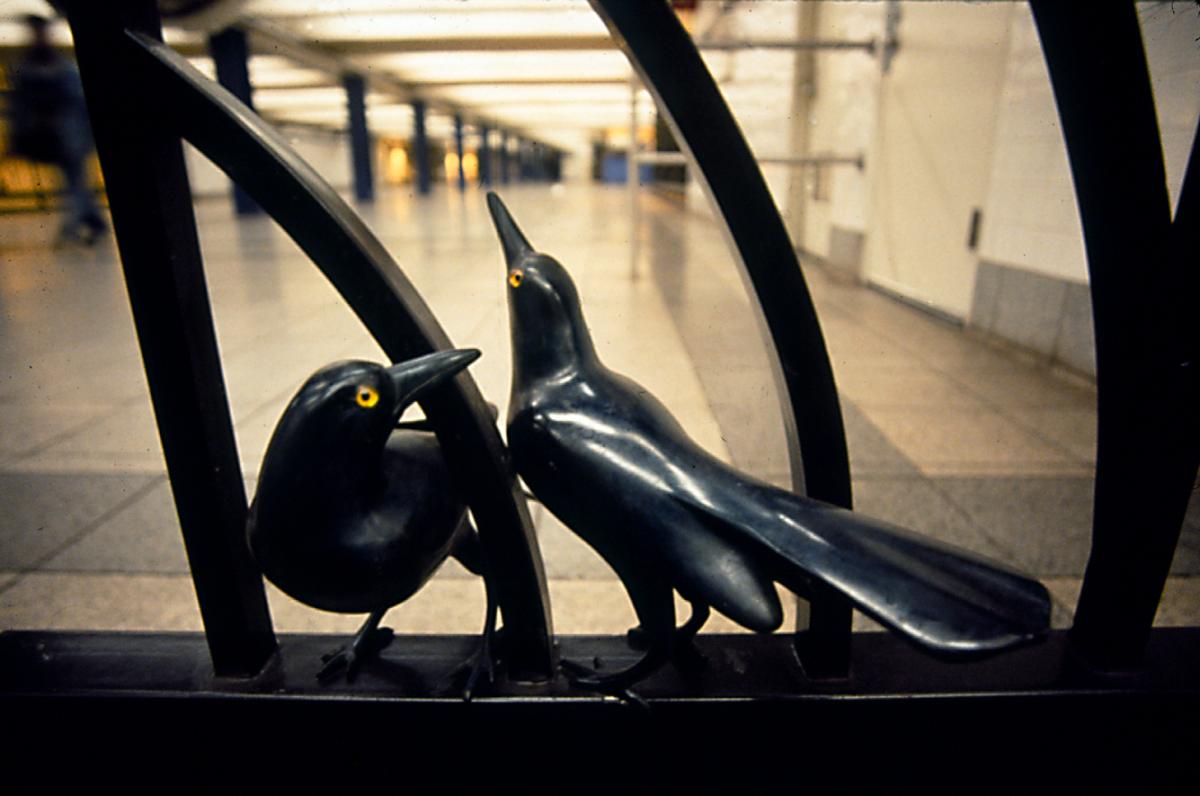 Artwork in bronze Walter Martin and Paloma Muñoz showing dozens of sculptural birds in different poses on the station gates and railings. 
