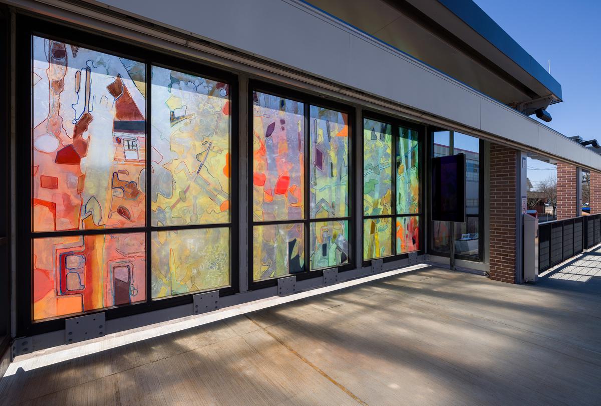 Artwork in laminated glass by Sandy Litchfield showing abstract shapes in forms in various colors.    