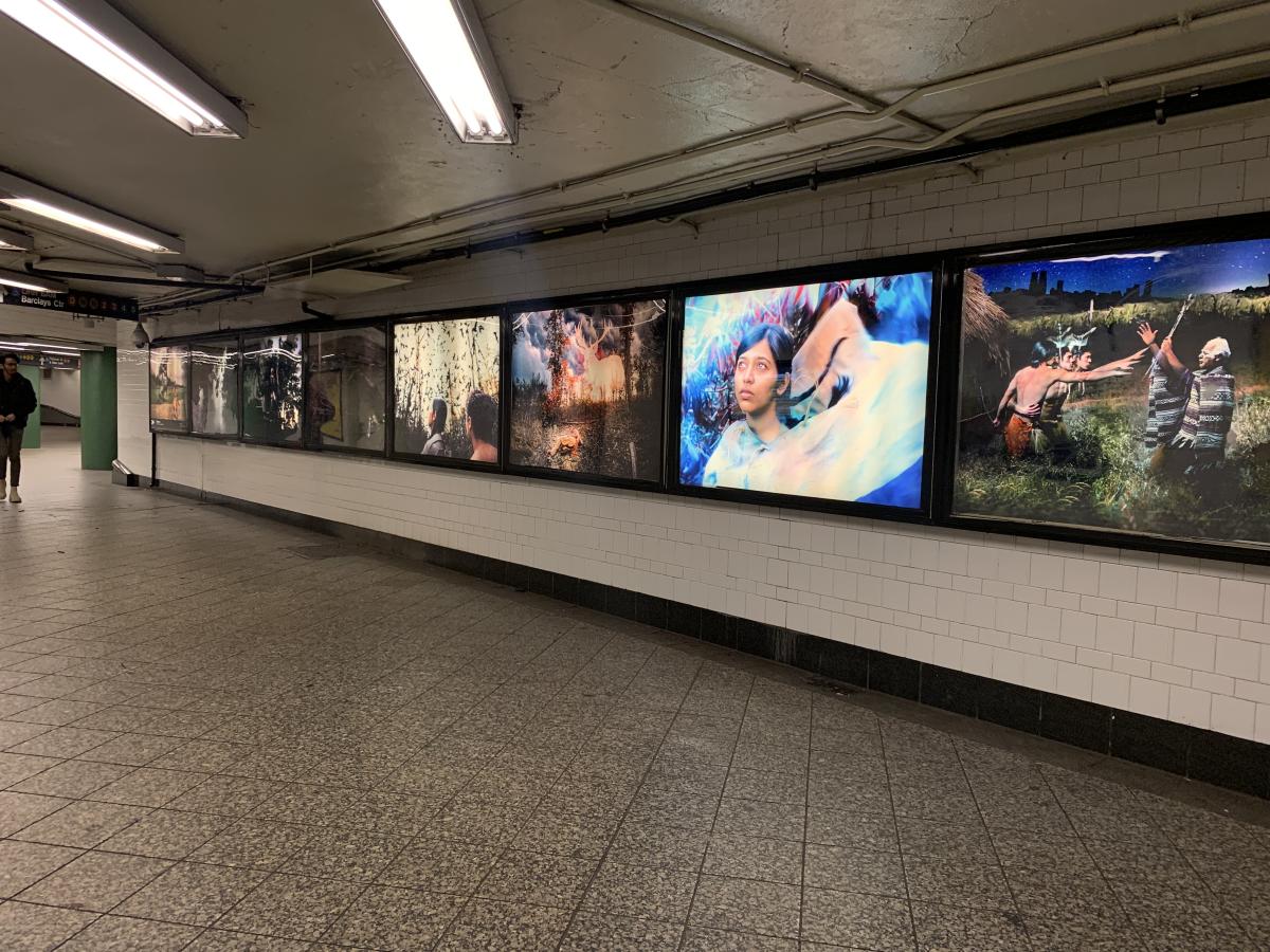 An photograph of a series of eight lightboxes installed in a subway station.