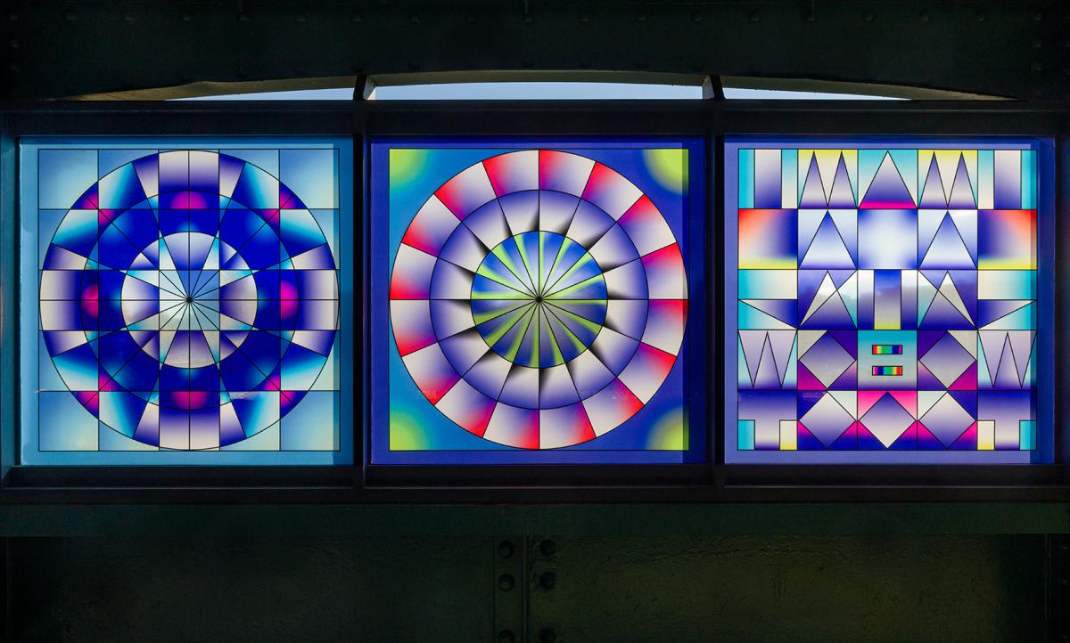 Three glass artwork panels depicting rainbow mandalas.