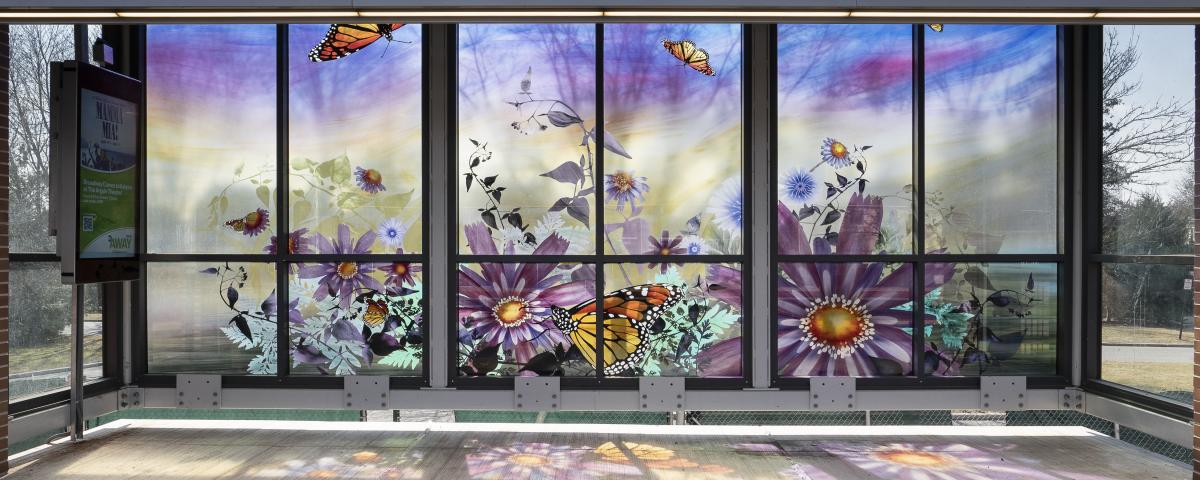 Glass artwork in a station shelter depicting flowers and butterflies.