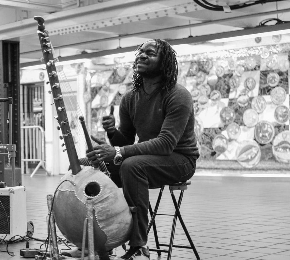 Black and white picture of man playing Kora.