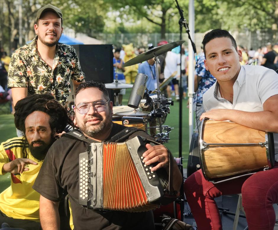 Four men posing with accordion and percussion.