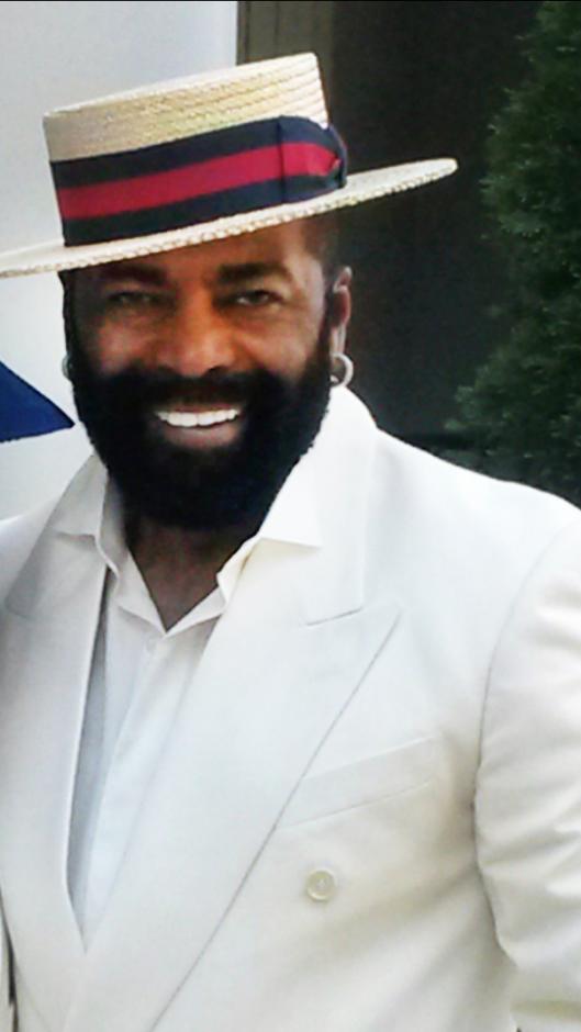 Man in white suit and straw boater hat.