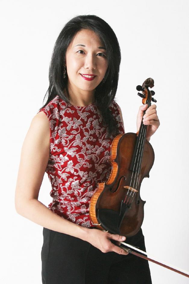 Woman in red and silver top posing with a violin.