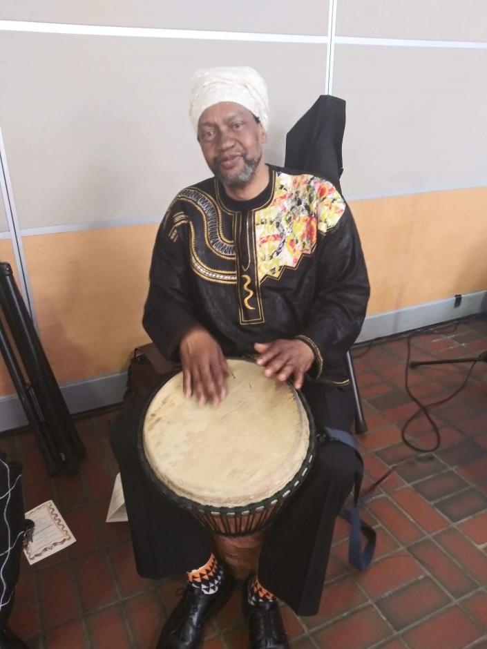 Man in traditional clothes posing with a djembe.