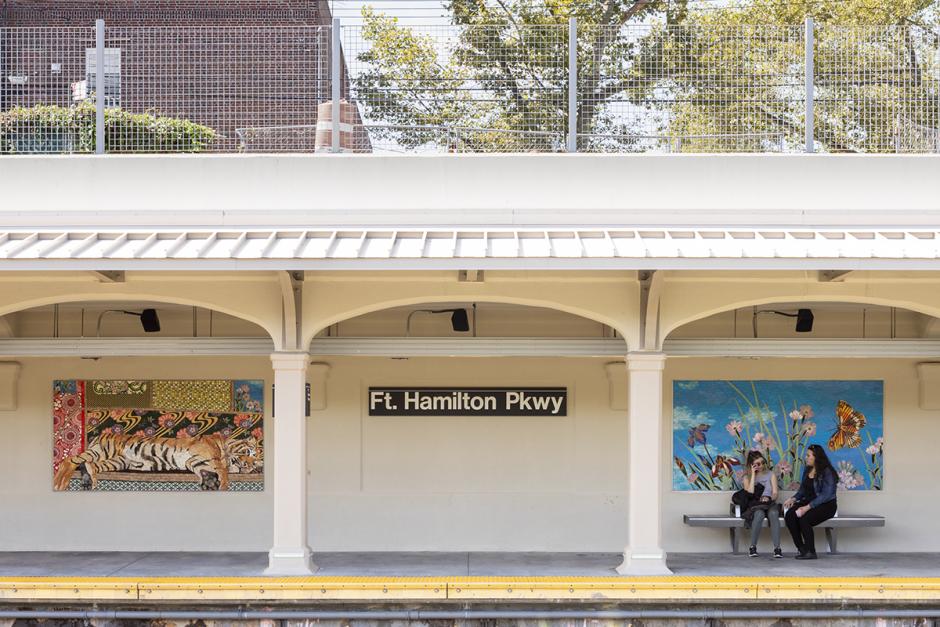 A permanent glass and ceramic mosaic art installation by artist Maria Berrio on the platform walls of the NYCT Fort Hamilton Pkwy station shows two mosaic panels from across the platform, a resting tiger on the left and flowers and butterflies against a blue sky on the right, with two women in front waiting on a metal bench.