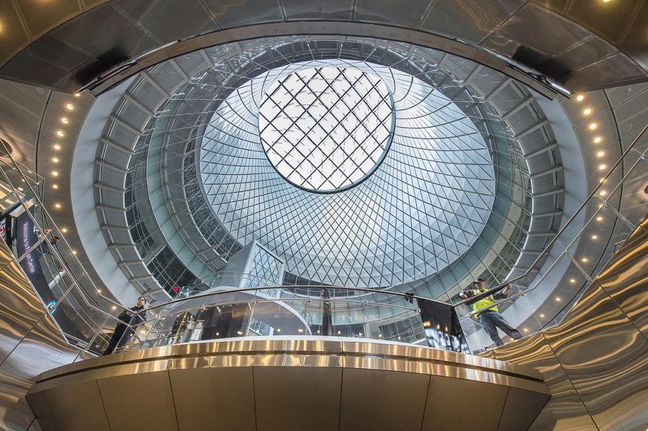 Artwork made from perforated optical-aluminum panels, stainless steel cables and fittings by James Carpenter Design Associates, Grimshaw Architects and ARUP, showing a large circular sculpture installed in the ceiling of Fulton Center that lets in an abundance of light into the station. 