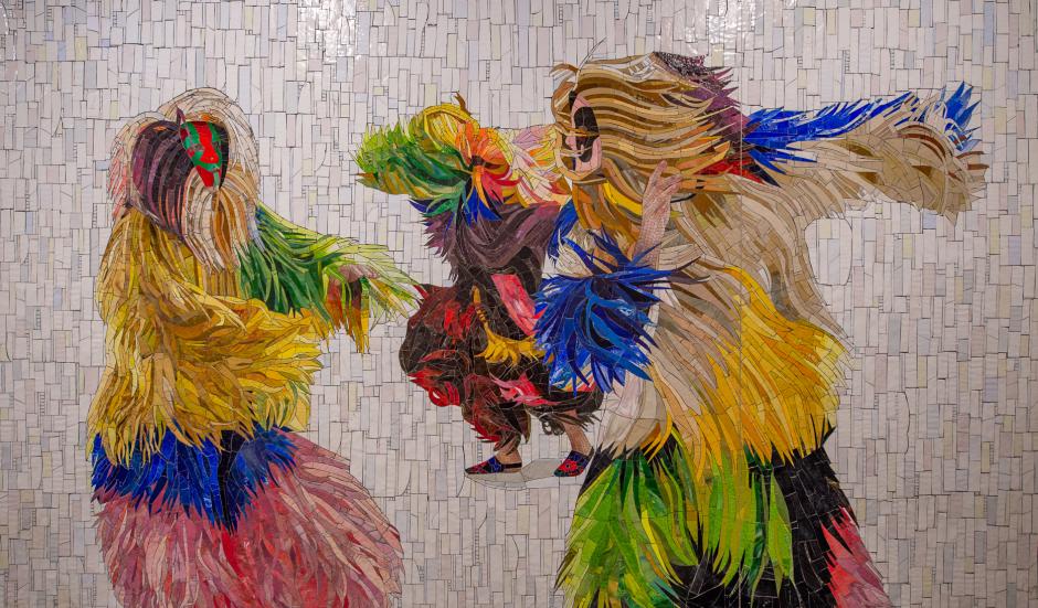 Artwork in mosaic by Nick Cave showing people dancing in brightly colored costumes known as Soundsuits. 