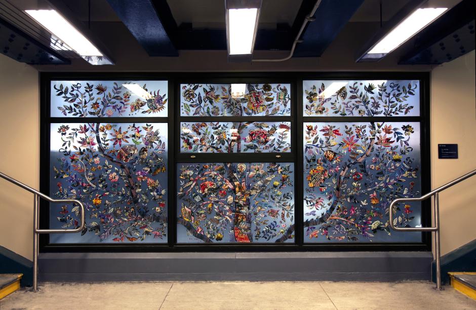 Artwork in laminated glass by Xin Song  showing photo papercuts formed into the shapes of trees, flowers and birds.  