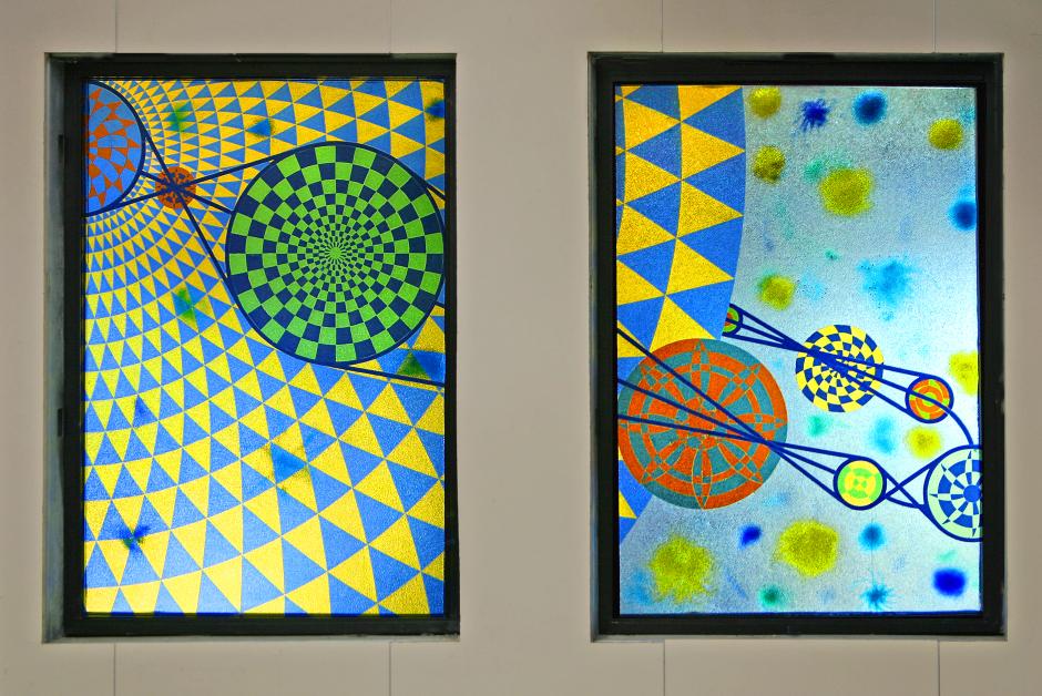 Artwork in laminated glass by Laura Battle showing circles and spheres in blues a, greens and yellows, evoking the phases of the moon and celestial navigation.