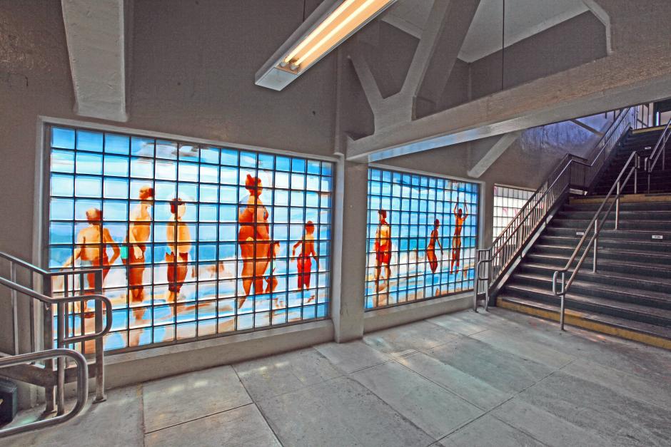 Artwork in glass block by Simon Levenson showing figures at the beach.