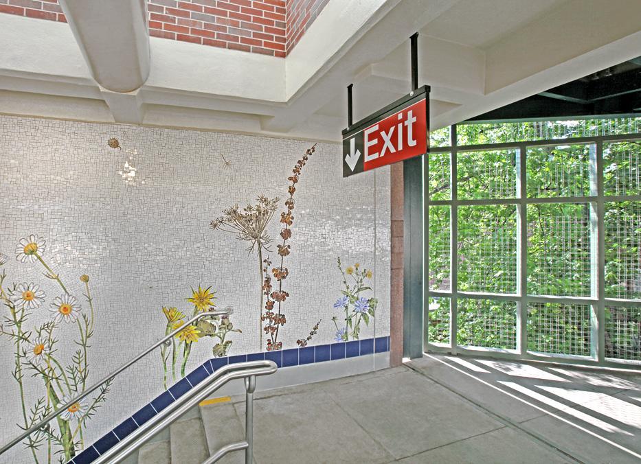 Artwork in glass mosaic by Jason Middlebrook showing large wildflowers climbing up the station stair walls.