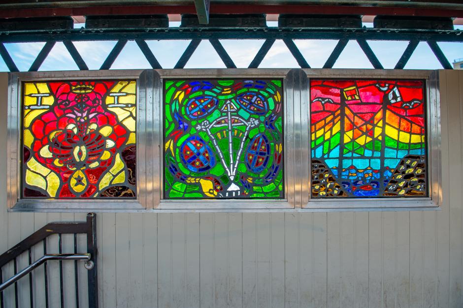 Artwork in faceted glass by SOL’SAX showing vibrant colors and intricate designs of city life and abstract symbols.