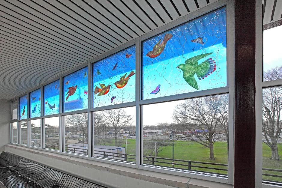 Artwork in laminated and tempered glass by Carson Fox showing a blue sky with butterflies and birds.