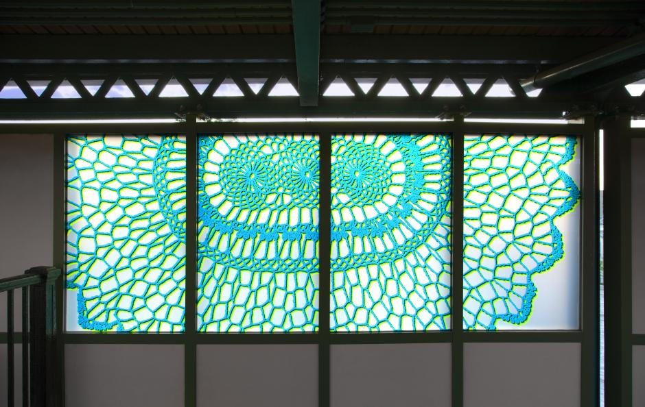 Artwork in laminated glass by Susanna Starr showing colorful shapes that resemble lace. 